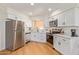 Bright kitchen boasts stainless steel appliances, white cabinets, and wood-look flooring at 7444 N 43Rd Ln, Glendale, AZ 85301