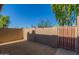 Enclosed private patio with secure brown wooden entry gate and desert landscaping at 7444 N 43Rd Ln, Glendale, AZ 85301