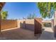 Enclosed private patio with secure brown wooden entry gate and desert landscaping at 7444 N 43Rd Ln, Glendale, AZ 85301