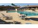 Outdoor pool with blue chairs and tables with an umbrella on the pool deck at 7750 E Broadway Rd # 400, Mesa, AZ 85208