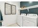 Efficient laundry room featuring modern washer and dryer with shelf and framed art at 8517 W Mantle Way, Florence, AZ 85132