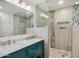 Elegant bathroom with teal vanity, double sinks, and a glass shower at 8620 E Starlight Way, Scottsdale, AZ 85250