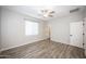 Well-lit bedroom with wood-look floors, ceiling fan and en-suite bathroom at 11472 W Cumberland Dr, Youngtown, AZ 85363