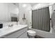 Bright bathroom featuring a single sink vanity, tub with shower, and neutral color scheme at 11517 E Unity Ave, Mesa, AZ 85212