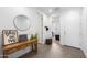 Inviting entryway with wood-look floors, decorative table, round mirror, and neutral wall color at 11517 E Unity Ave, Mesa, AZ 85212