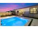 The sparkling pool and patio are illuminated against the dusk sky, offering a serene outdoor retreat at 11517 E Unity Ave, Mesa, AZ 85212
