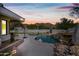 Luxury pool with waterfall feature at sunset, mountain backdrop at 12129 N 114Th Way, Scottsdale, AZ 85259
