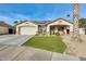 Single-story home with a landscaped lawn, two-car garage, and solar panels at 12858 W Wilshire Dr, Avondale, AZ 85392