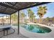 Inviting kidney-shaped pool with pergola, surrounded by lush landscaping at 12858 W Wilshire Dr, Avondale, AZ 85392