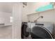 Laundry room with a new washer and dryer set, overhead shelving, and access to the main living area at 1351 N Pleasant Dr # 1102, Chandler, AZ 85225