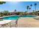 Community pool featuring palm trees, lounge chairs, and a clear blue swimming pool at 1351 N Pleasant Dr # 1102, Chandler, AZ 85225