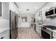 Updated kitchen with white shaker cabinets, stainless steel appliances, and subway tile backsplash at 1542 W Loma Ln, Phoenix, AZ 85021