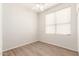Clean bedroom design with neutral walls, wood-look floors, bright window, and a ceiling fan at 19520 N 65Th Ave, Glendale, AZ 85308