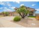 Tan home featuring a three-car garage, desert landscaping, and a red tile roof at 19520 N 65Th Ave, Glendale, AZ 85308