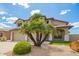 Tan home featuring a three-car garage, desert landscaping, and a red tile roof at 19520 N 65Th Ave, Glendale, AZ 85308