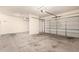 Spacious three-car garage with ample room for parking and storage, featuring two garage doors and concrete floors at 19520 N 65Th Ave, Glendale, AZ 85308