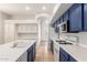 Bright kitchen with white and navy cabinets, an island with a sink, and stainless steel appliances for modern cooking at 19520 N 65Th Ave, Glendale, AZ 85308