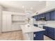 Modern kitchen boasts white and navy cabinets, a large island, and stainless steel appliances for culinary enthusiasts at 19520 N 65Th Ave, Glendale, AZ 85308