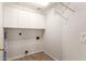 Practical laundry room with overhead cabinets, tile flooring, and washer and dryer hookups at 19520 N 65Th Ave, Glendale, AZ 85308