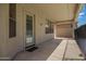 Covered back patio with concrete flooring, offering a view of the pool and yard through windows and a door at 19520 N 65Th Ave, Glendale, AZ 85308