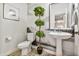 Elegant powder room with pedestal sink and artistic wallcovering at 2404 E Gillcrest Rd, Gilbert, AZ 85298