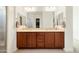 Bathroom with double sinks, wood cabinets, tile floor and generous mirror space at 26921 N 100Th Ave, Peoria, AZ 85383