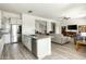 Open-concept kitchen with a center island, stainless steel appliances, and a view of the living area at 26921 N 100Th Ave, Peoria, AZ 85383