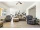 Spacious living room with light hardwood floors and an open layout to the kitchen at 26921 N 100Th Ave, Peoria, AZ 85383