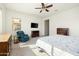 Bright main bedroom with a ceiling fan, comfortable chair, and view of the backyard at 26921 N 100Th Ave, Peoria, AZ 85383