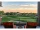 Relaxing balcony showcasing a tranquil golf course view at sunset with comfortable orange lounge chairs at 37200 N Cave Creek Rd # 2127, Scottsdale, AZ 85262