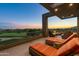 Relaxing balcony with comfortable lounge chairs overlooking a beautifully lit golf course at sunset at 37200 N Cave Creek Rd # 2127, Scottsdale, AZ 85262