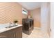 Convenient laundry room featuring modern machines, sink, and patterned tile floors at 37200 N Cave Creek Rd # 2127, Scottsdale, AZ 85262