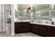 Bathroom features dual vanity sinks, dark wood cabinets, a large mirror, and access to a walk-in shower at 4905 E Estevan Rd, Phoenix, AZ 85054