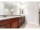 Double vanity bathroom with granite countertops and dark wood cabinets at 5575 W Cinder Brook Way, Florence, AZ 85132