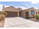 Single-story home with a two-car garage and desert landscaping at 5575 W Cinder Brook Way, Florence, AZ 85132
