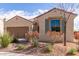 Tan house with two-car garage, featuring drought-resistant landscaping at 5575 W Cinder Brook Way, Florence, AZ 85132