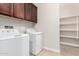 Bright laundry room with washer, dryer, and storage at 5575 W Cinder Brook Way, Florence, AZ 85132