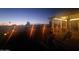 Relaxing covered patio area with lounge chairs, ambient lighting, and views of the backyard at twilight at 650 N Hawes Rd # 2713, Mesa, AZ 85207