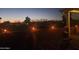 Outdoor patio area with seating, a brick wall, and lighting overlooking the yard at dusk at 650 N Hawes Rd # 2713, Mesa, AZ 85207