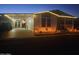Charming single-Gathering home with a covered parking area, landscape, and warm lighting at twilight at 650 N Hawes Rd # 2713, Mesa, AZ 85207
