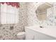 Bathroom with floral wallpaper and a white vanity, toilet, and fixtures at 10437 W Caron Dr, Sun City, AZ 85351