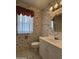 Small bathroom with floral wallpaper, white vanity, and tiled floor at 10437 W Caron Dr, Sun City, AZ 85351