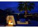 Night view of backyard patio, fireplace, and city lights at 10788 E Raintree Dr, Scottsdale, AZ 85255