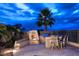 Evening view of backyard patio with fireplace and BBQ at 10788 E Raintree Dr, Scottsdale, AZ 85255