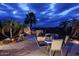 Night view of backyard patio with fireplace and seating at 10788 E Raintree Dr, Scottsdale, AZ 85255