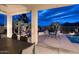 Covered patio with dining table and pool view at night at 10788 E Raintree Dr, Scottsdale, AZ 85255