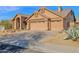 Exterior showcasing a house with a tan facade, tiled roof, and a spacious three-car garage at 11222 E Oberlin Way, Scottsdale, AZ 85262