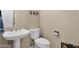 Cozy powder room with pedestal sink, toilet, and decorative mirror at 11222 E Oberlin Way, Scottsdale, AZ 85262