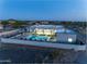 An aerial view of the property with a pool, patio, and desert landscaping at dusk at 12560 E Cochise Dr, Scottsdale, AZ 85259