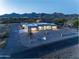 Dusk aerial view of a desert home with desert landscaping and mountain views at 12560 E Cochise Dr, Scottsdale, AZ 85259